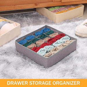 A gray fabric drawer organizer with multiple compartments neatly stores rolled socks in various colors. The organizer sits on a fluffy gray rug, partially pulled out from under a wooden dresser. Other similar organizers with different types of clothing are partially visible nearby. Text at the bottom reads DRAWER STORAGE ORGANIZER.drawer organizer, sock organizer, clothes organizer, wardrobe organiser, household items, home essentials, home improvement store, home improvement, storage solutions.
