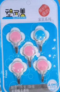 Close-up of a pack of five self-adhesive plastic wall hooks in a flower-like design. The hooks have a clear base with colorful centers (pink and blue). The packaging indicates they are "strong" and suitable for home use, with a weight capacity of 2.0KG. These are easy-to-install, no-drill hooks for organizing lightweight items. Keywords: self-adhesive hooks, wall hooks, plastic hooks, home organization, no drill hooks.
