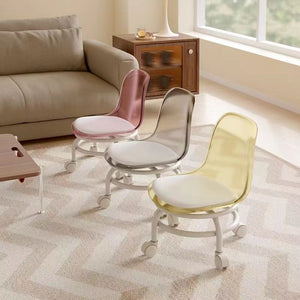 Three acrylic swivel chairs in pink, clear, and yellow with white cushions and bases are on a patterned rug.Acrylic chair, swivel chair, modern chair, office chair.