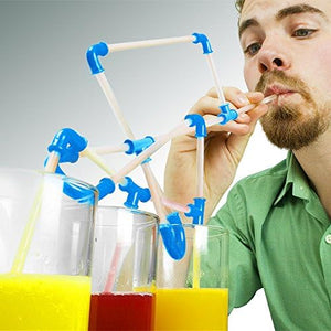 A man with a beard drinks from a complex, clear plastic straw structure connected by blue joints, leading to three glasses filled with yellow and red liquids.crazy straws, DIY straws, novelty straws, drinking straws, fun, playful.