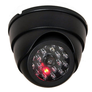 A black, dome-shaped fake security camera with multiple clear and one red LED light is shown.fake security camera, dummy camera, surveillance.