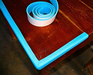 A roll of light blue KiddySafe edge protector tape sits on a dark wooden table. A strip of the tape has been applied to the edge and corner of the table.KiddySafe, edge protector, safety tape, furniture guard, baby proofing.