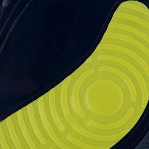 Close-up of a shoe sole featuring a lime green section with concentric circular and wavy patterns, set against a dark, contrasting background. The modern design integrates shoe insert insoles for enhanced foot arch support.