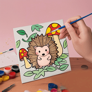 A hand holding a blue paintbrush is shown painting a pre-drawn canvas featuring a cute hedgehog with textured brown quills, surrounded by colorful mushrooms and green leaves. Small pots of paint in various colors are scattered on the wooden surface below the canvas. home decor items, home decor, wall hooks, shelves, home improvement store, home improvement, household items, home essentials