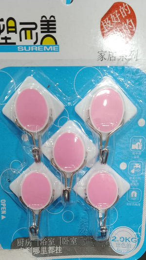 Close-up of a pack of five self-adhesive plastic wall hooks in a flower-like design. The hooks have a clear base with colorful centers (pink and blue). The packaging indicates they are "strong" and suitable for home use, with a weight capacity of 2.0KG. These are easy-to-install, no-drill hooks for organizing lightweight items. Keywords: self-adhesive hooks, wall hooks, plastic hooks, home organization, no drill hooks.