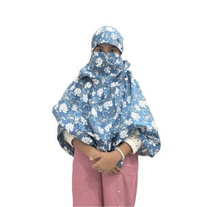 A girl wearing a Blue and White paisley-patterned hijab that covers their head, neck, and most of their face, with only their eyes visible.