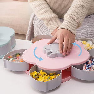 A Pink flower-shaped rotating tray with Five clear compartments filled with Toffy and Chocolate.snack tray, rotating, nuts, dried fruit, serving.