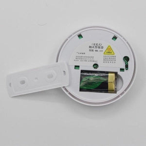 The back of a white SS-168 fire smoke alarm detector is shown with its battery compartment open, revealing a gold-colored battery. Chinese text and symbols are printed on the back of the device.SS-168 Fire Smoke Alarm Detector, smoke detector, fire alarm, battery powered, home safety, safety device, household items, home essentials.