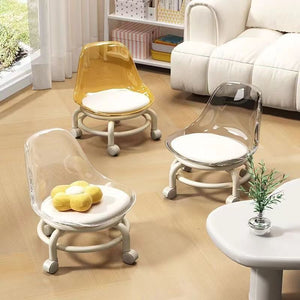Three acrylic swivel chairs in Golden, clear, and yellow with white cushions and bases are on a rug.