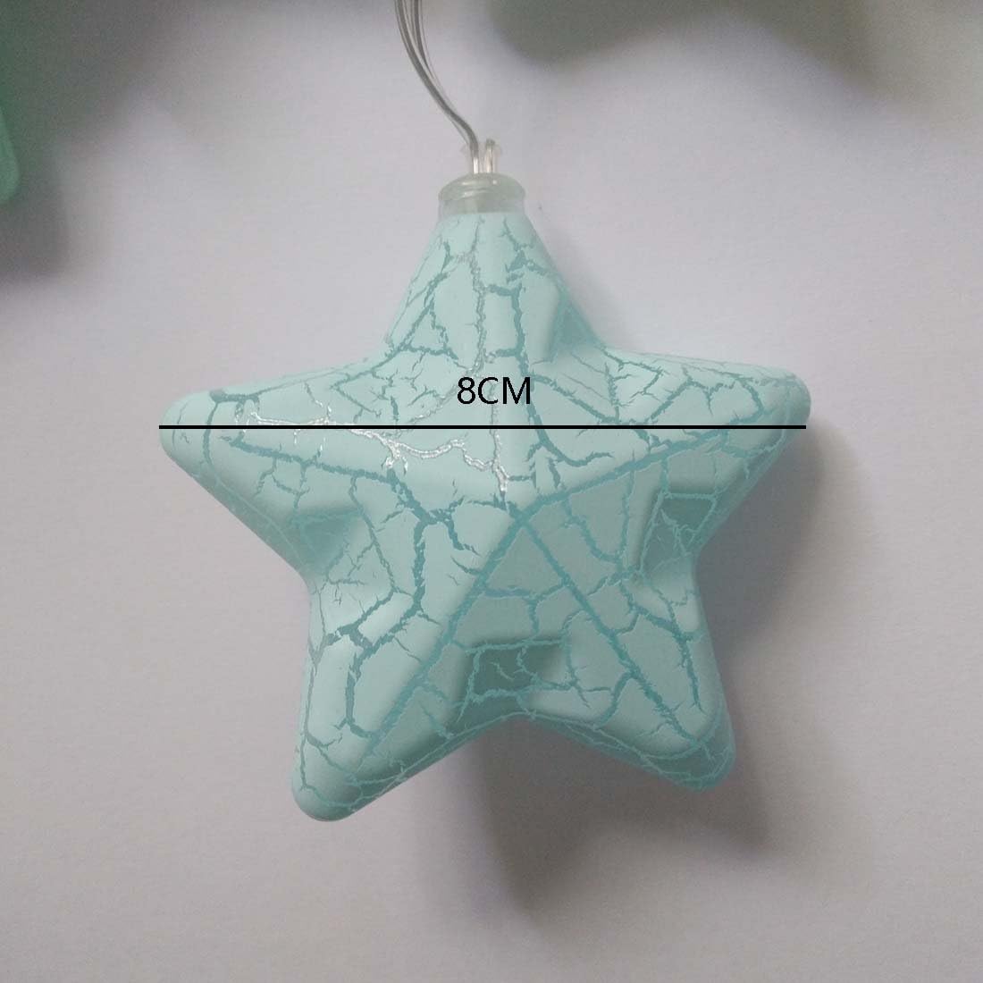 Close-up of a transparent plastic star housing a glowing warm white LED bulb, highlighting the fine details and build quality of the night light