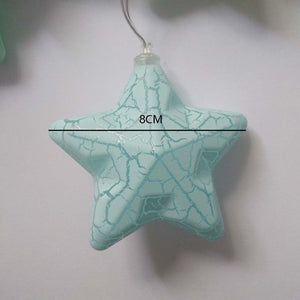 Close-up of a transparent plastic star housing a glowing warm white LED bulb, highlighting the fine details and build quality of the night light
