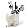 A cream-colored, geometric elephant-shaped tableware storage container holds assorted silverware, including forks and spoons. The elephants trunk serves as a spout, blending functionality with a whimsical touch.