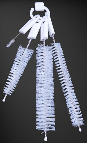 Four white cleaning brushes of varying sizes hang from a white ring against a dark background.bottle brush, cleaning brush, kitchen brush, set.