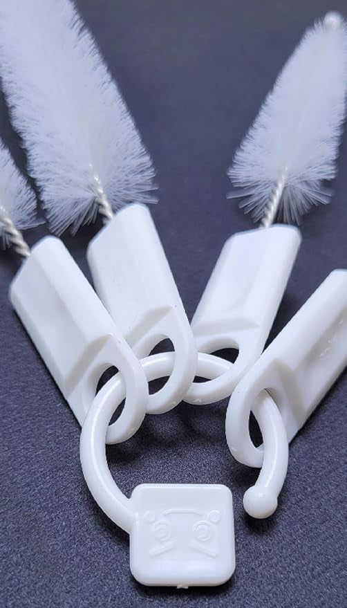 Close-up of four white brush handles connected by a white ring.brush set, cleaning tools, detail.