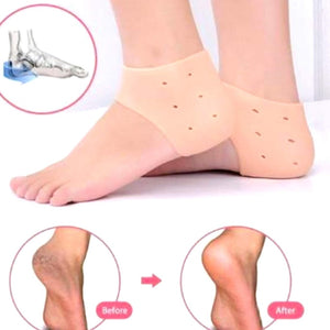 A close-up shows two bare feet, each wearing a beige silicone heel protector that covers the heel and has small ventilation holes.silicone heel protector, heel sleeve, heel cushion, foot protection, plantar fasciitis, heel pain, foot care, health and personal care.