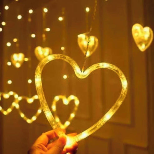 Heart-shaped curtain ligh in hand