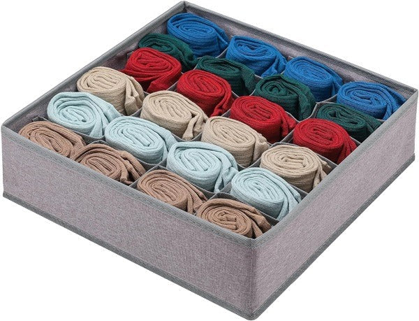 A gray fabric drawer organizer with multiple compartments neatly stores rolled socks in various colors. drawer organizer, sock organizer, clothes organizer, wardrobe organiser, household items, home essentials, home improvement store, home improvement, storage solutions.