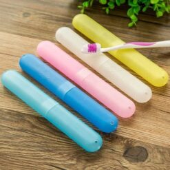 Plastic toothbrush cover presented in sky blue, blue, pink, white, and yellow color on a wooden table.