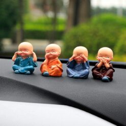 4 buddha statue is placed of a car dashboard.