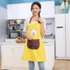 A girl is standing in kitchen wearing yellow color kitchen cooking apron.