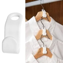 White color clothes hanger extender. 3 white color shirts are hanged using clothes hanger extender.