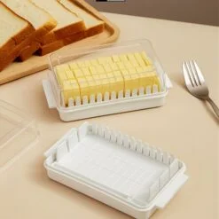 Butter cutting storage box along with butter in it. Besides that, few breads in a tray is presented and a fork is kept.