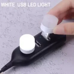 1 watt usb bulb is switched on using usb. Woman is trying to insert another 1 watt usb bulb to show how to use it.