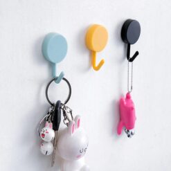 The image shows how the product will look when you buy hooks online from 99wholesale. The product shows blue, yellow, and black sticky hanging hooks mounted on wall.