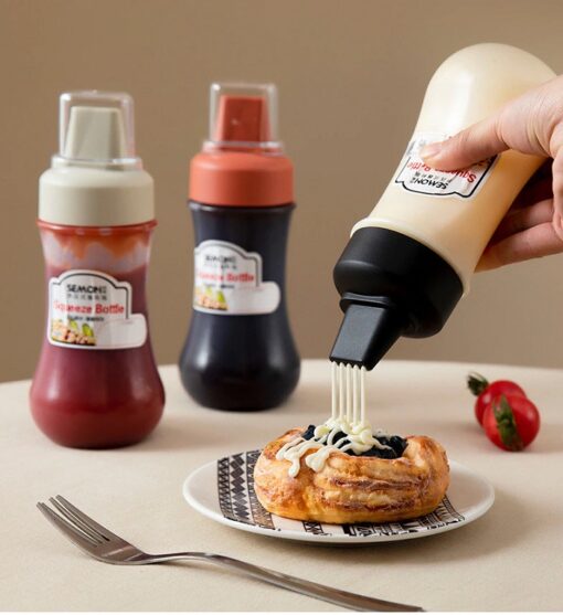 3 plastic squeeze bottles for sauces are kept besides each other. Woman is using condiment squeeze bottles for seasoning.