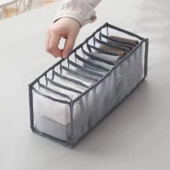 11 compartment transparent clothes storage organizer is filled with clothes.