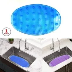 Blue color oval shape anti slip sink mat is placed in left sink & in the right, purple color anti slip sink mat is placed.