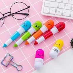 different color capsule shape ball pen are kept near keyboard and specs