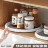 Woman is organizing different bottles in a plastic rotating organizer under the cabinet.