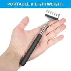 Stainless steel back scratcher with black handle is placed in a hand.