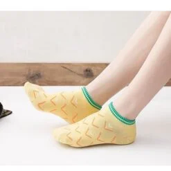 Yellow printed ankle socks are worn by a female.