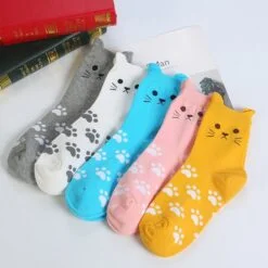 5 different color cat paw socks for women are placed on a table.