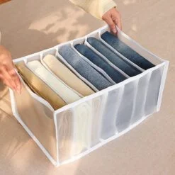 Jeans are organized in a 7 Compartment Transparent Clothes Storage Organiser.
