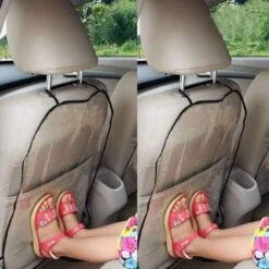 A girl kid is placing her feet on a car seat back protector.