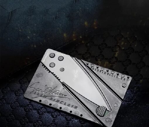 Credit card size folding knife is shown in a black background.
