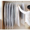 Women is organizing her clothes in her wardrobe by using hanging clothes cover.