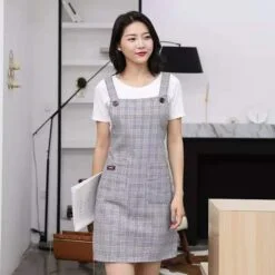 a girl is wearing a grey color kitchen cooking apron