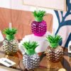 Pineapple water bottle with straw is presented in 4 different colors on a glass table.