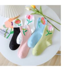 Black, white, pink, blue, and green color flower design socks are placed in a row.