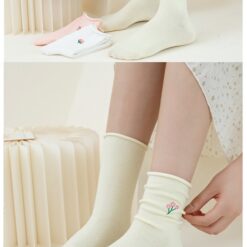 A girl is wearing cream color flower design socks.