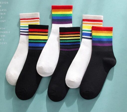 Different colors rainbow striped socks are shown in a row on a blue background.