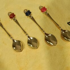 Stainless steel gold spoon with yellow, maroon, green, and red color top.