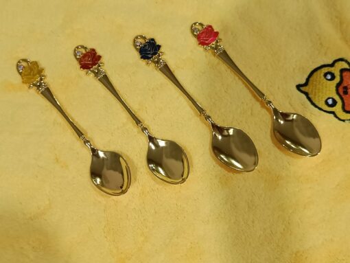 Stainless steel gold spoon with yellow, maroon, green, and red color top