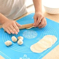 Man is using blue color silicone fondant rolling mat for making chapatis.