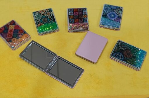 Travel pocket mirror is shown in different designs and colors.