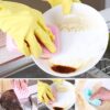 Woman is washing dishes in the sink using kitchen cleaning sponge.